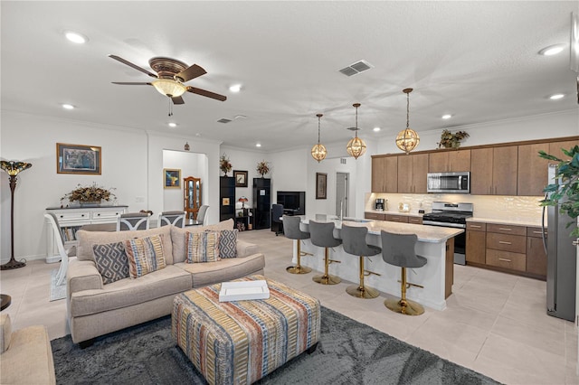 living room with light tile patterned floors, ceiling fan, ornamental molding, and sink