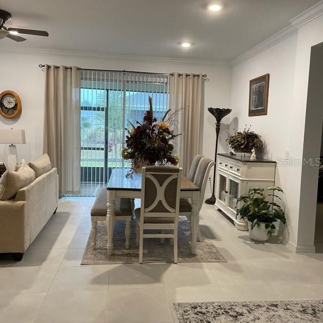 tiled dining room featuring ceiling fan and crown molding