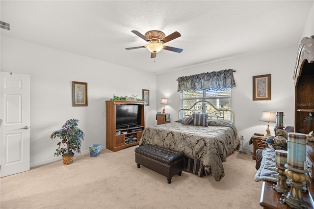 carpeted bedroom featuring a textured ceiling and ceiling fan