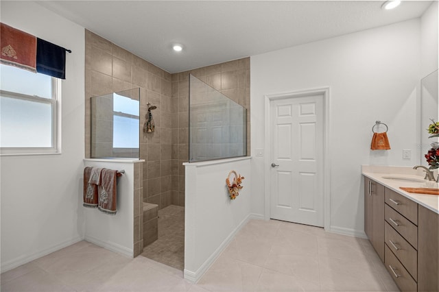 bathroom with tile patterned floors, vanity, and tiled shower