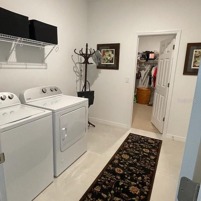 laundry area with washing machine and dryer and light tile patterned floors