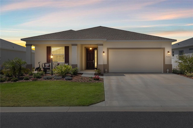 view of front facade with covered porch, a front yard, concrete driveway, an attached garage, and stucco siding