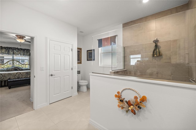 ensuite bathroom with connected bathroom, toilet, tile patterned floors, and walk in shower