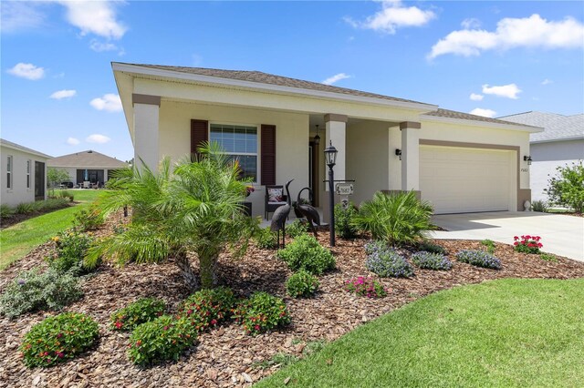 view of front facade featuring concrete driveway, stucco siding, covered porch, and a garage
