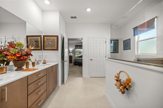 bathroom featuring visible vents, double vanity, ensuite bath, and a wealth of natural light
