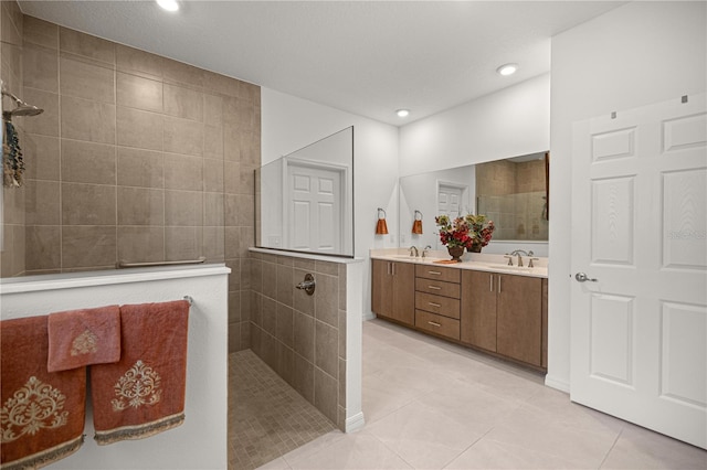 full bathroom featuring a sink, a walk in shower, tile patterned floors, and double vanity