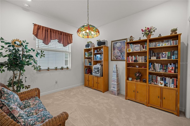 sitting room featuring baseboards and light colored carpet