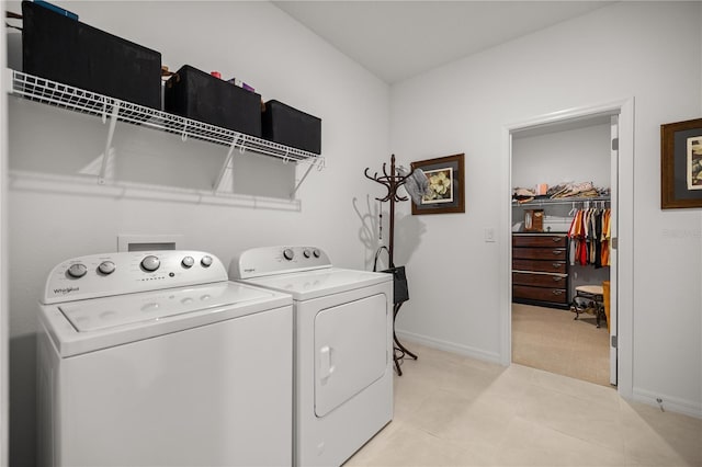 laundry area featuring washer and dryer, light tile patterned flooring, laundry area, light colored carpet, and baseboards