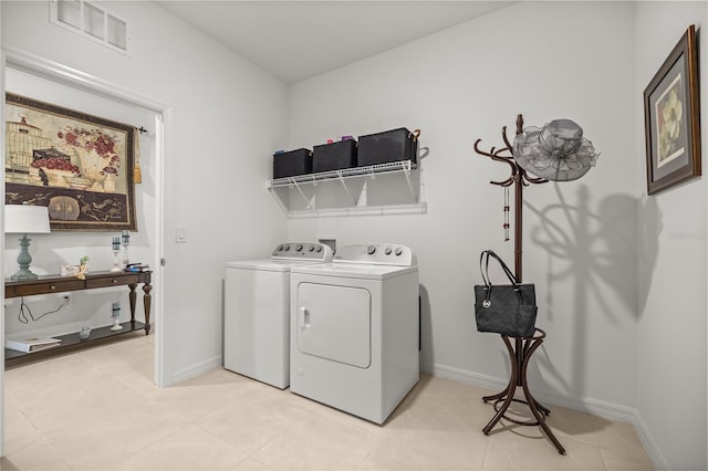 washroom featuring washing machine and clothes dryer, laundry area, visible vents, and baseboards