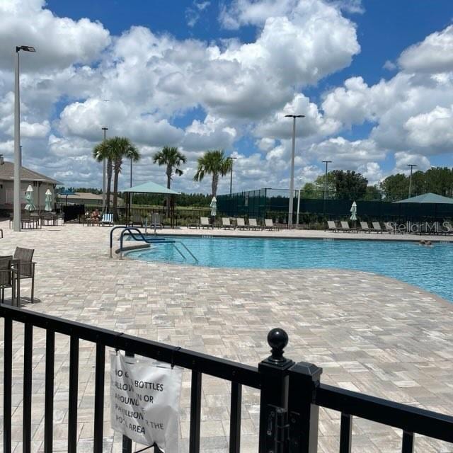community pool featuring a patio and fence