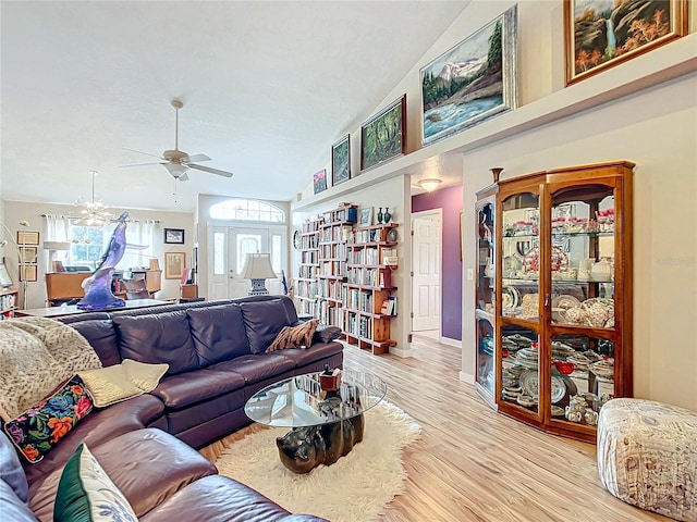 living room with light hardwood / wood-style flooring, vaulted ceiling, and ceiling fan