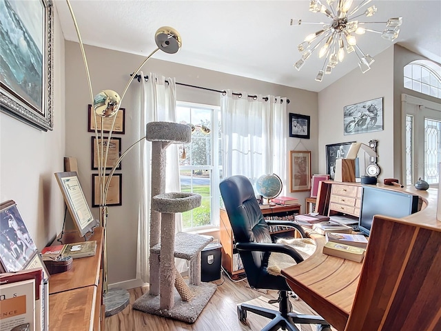 home office with plenty of natural light, a chandelier, vaulted ceiling, and wood-type flooring