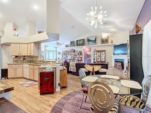 kitchen with light stone countertops, light brown cabinetry, sink, light hardwood / wood-style floors, and lofted ceiling