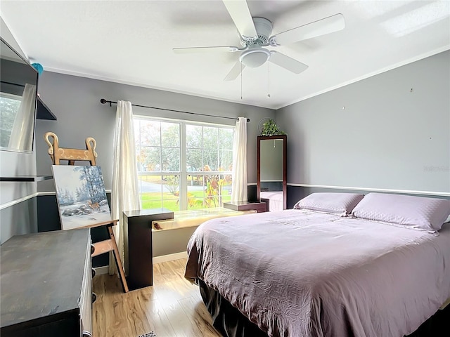 bedroom featuring ceiling fan, crown molding, and light hardwood / wood-style flooring