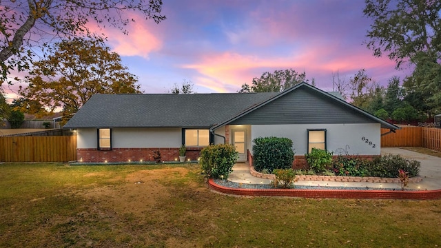 ranch-style home with a yard