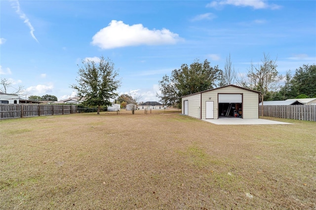 view of yard with a garage and an outbuilding