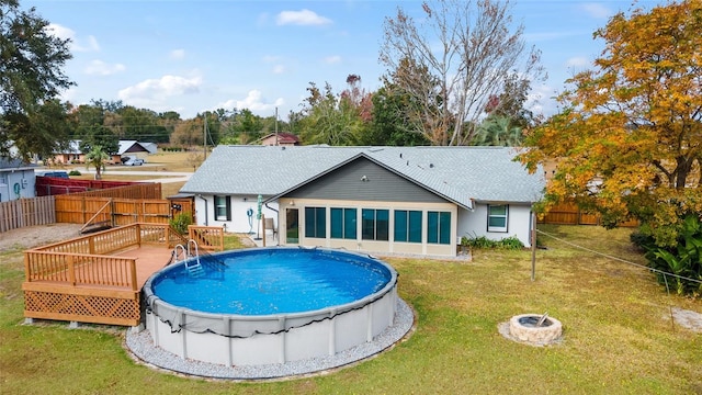 view of swimming pool featuring an outdoor fire pit, a deck, and a yard