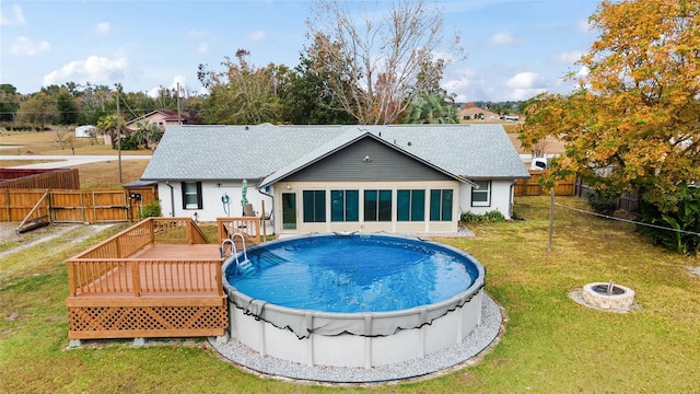 view of swimming pool with a deck, a lawn, and a fire pit