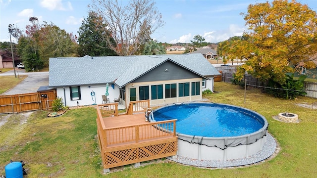 view of pool with a deck, a yard, and a fire pit