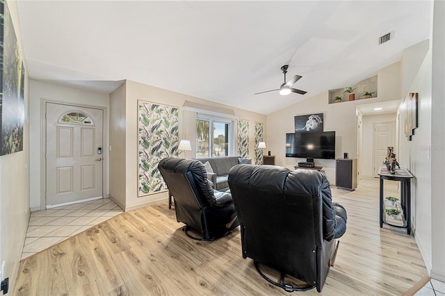 living room with vaulted ceiling, ceiling fan, and light hardwood / wood-style flooring