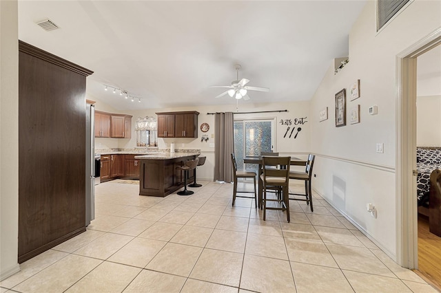 tiled dining area featuring ceiling fan and lofted ceiling