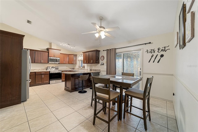 tiled dining room featuring ceiling fan and lofted ceiling