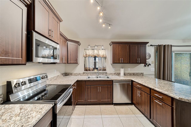 kitchen featuring light stone countertops, dark brown cabinetry, stainless steel appliances, sink, and light tile patterned floors