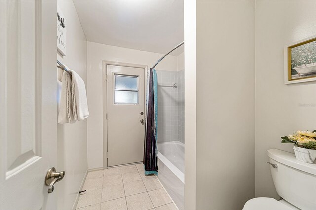 bathroom with tile patterned floors, toilet, and shower / bathtub combination with curtain