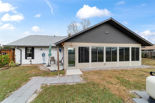 rear view of house featuring a lawn and a patio area