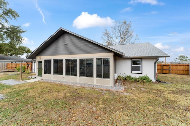 back of house with a yard and a sunroom