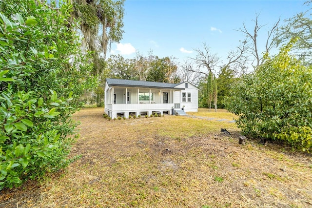 back of house with a porch and a lawn