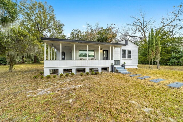 view of front of property featuring covered porch and a front yard