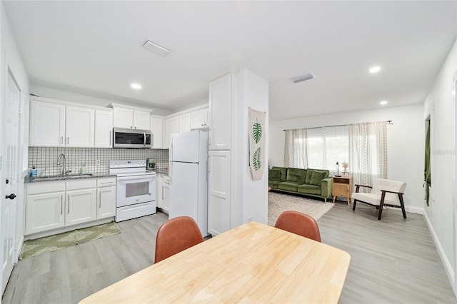 kitchen featuring sink, white appliances, white cabinetry, and light hardwood / wood-style flooring