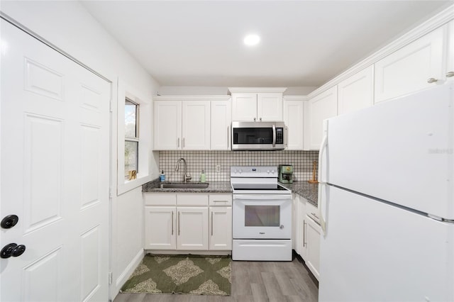 kitchen featuring sink, white appliances, white cabinetry, and light hardwood / wood-style flooring