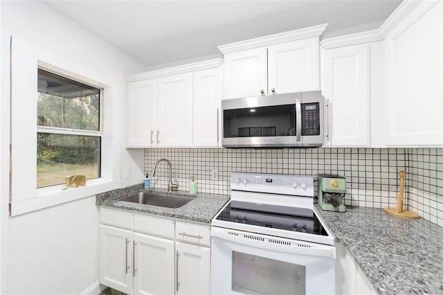 kitchen with decorative backsplash, white electric stove, white cabinets, light stone counters, and sink