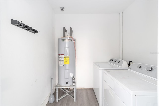 washroom featuring separate washer and dryer, light hardwood / wood-style flooring, and electric water heater