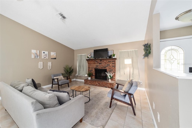 living room featuring light tile patterned floors, lofted ceiling, and a fireplace