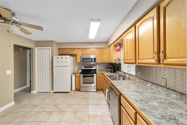 kitchen with light tile patterned floors, appliances with stainless steel finishes, sink, and tasteful backsplash