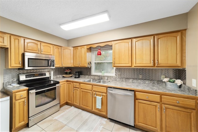 kitchen with light tile patterned floors, appliances with stainless steel finishes, decorative backsplash, and sink