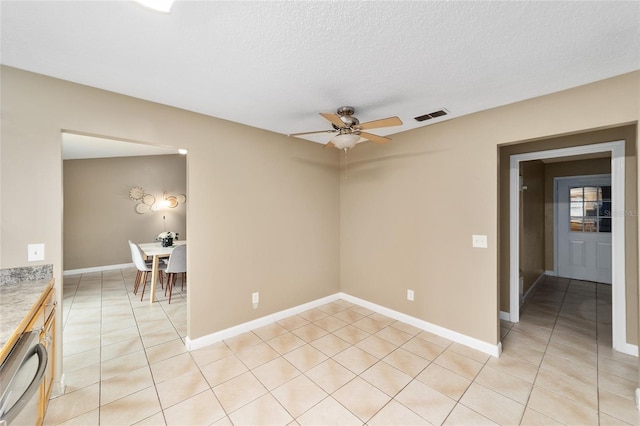 tiled spare room with ceiling fan and a textured ceiling