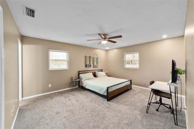 carpeted bedroom featuring ceiling fan and multiple windows