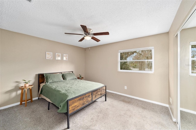 carpeted bedroom with a textured ceiling and ceiling fan