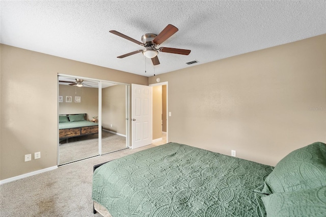 carpeted bedroom with ceiling fan, a textured ceiling, and a closet