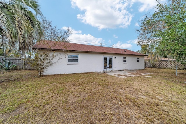 rear view of property featuring french doors and a lawn