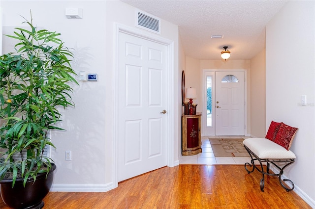 entrance foyer featuring a textured ceiling and light hardwood / wood-style flooring