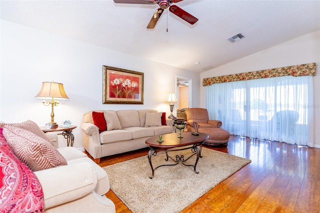 living room with ceiling fan, wood-type flooring, a textured ceiling, and lofted ceiling