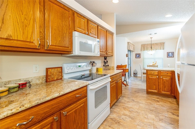 kitchen featuring white appliances, an inviting chandelier, hanging light fixtures, vaulted ceiling, and light stone counters