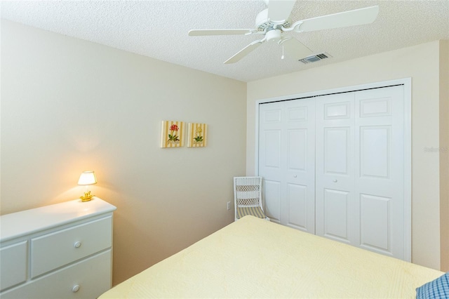 bedroom featuring ceiling fan, a closet, and a textured ceiling