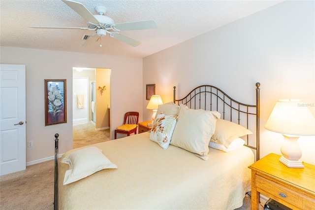 bedroom with a textured ceiling, light colored carpet, and ceiling fan