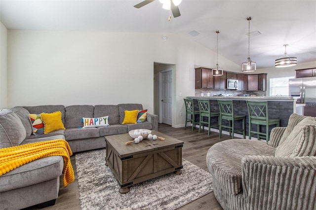 living room featuring lofted ceiling, ceiling fan, and dark wood-type flooring